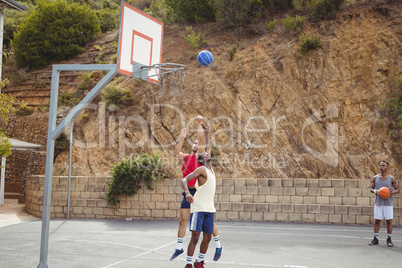 Basketball players playing in basketball court