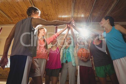 Female coach and high school kids giving high five to each other