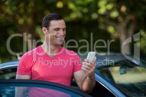 Man using mobile phone by car