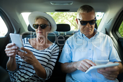 Senior couple using technologies in car