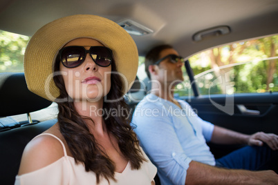 Couple wearing sunglasses traveling in car