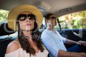 Couple wearing sunglasses traveling in car