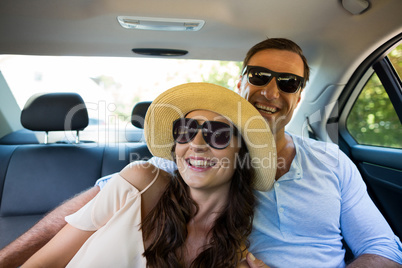 Cheerful couple wearing sunglasses in car