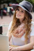 Portrait of woman using laptop at table in cafe