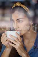 Close up of woman looking away while drinking coffee
