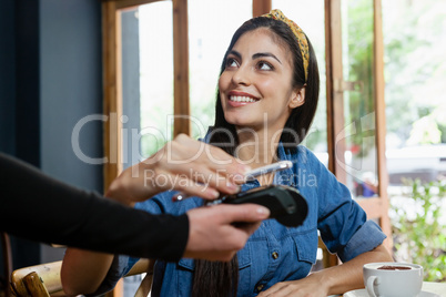 Smiling woman making payment on credit card reader