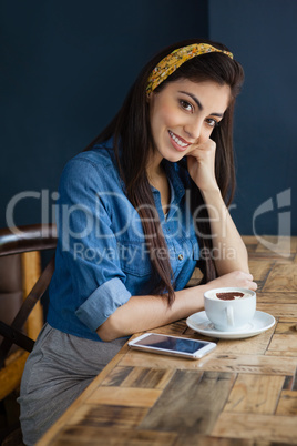 Portrait of smiling woman sitting at table