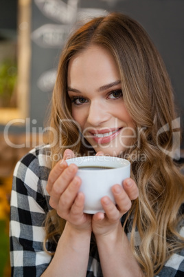 Portrait of young woman holding coffee cup