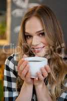 Portrait of young woman holding coffee cup