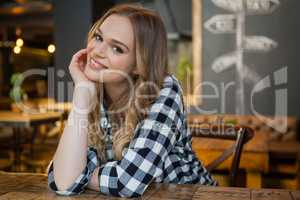 Portrait of young woman sitting at table