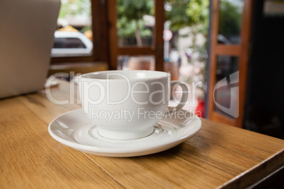 Close up of cup with saucer on wooden table