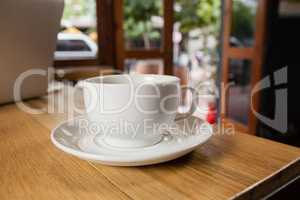 Close up of cup with saucer on wooden table