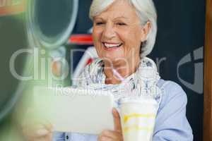 Happy woman holding digital tablet while sitting at cafe