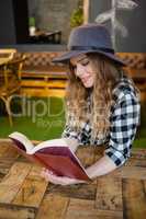 Beautiful woman wearing hat reading book