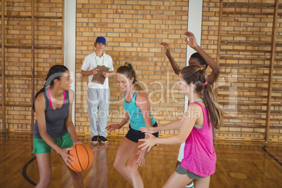 Coach watching the high school kids playing basketball