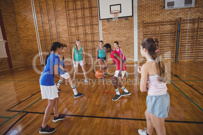 High school kids playing basketball in the court