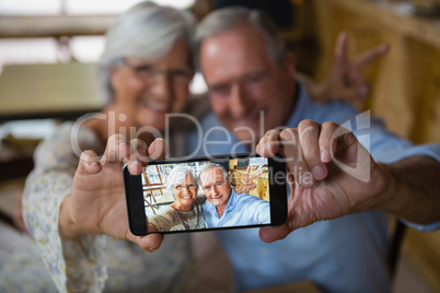 Happy senior couple taking selfie on mobile phone