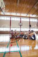 Basketball players interacting while relaxing in the court