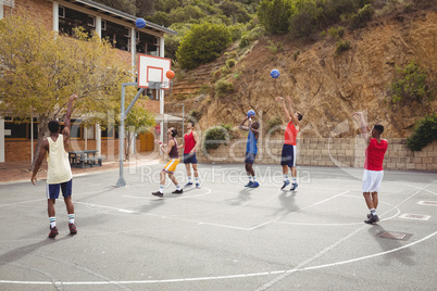 Basketball players practicing in basketball court
