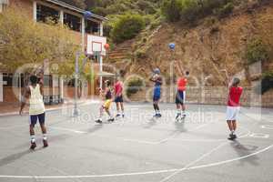 Basketball players practicing in basketball court