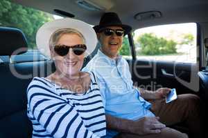 Cheerful senior couple sitting in car