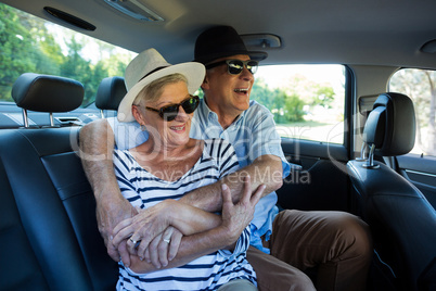 Senior couple enjoying on car back seat