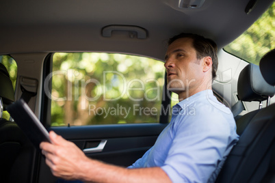 Man holding digital tablet in car