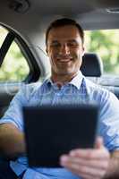 Man using digital tablet in car