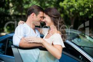 Young couple leaning on car
