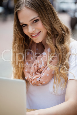 Portrait of woman using digital laptop while sitting at table