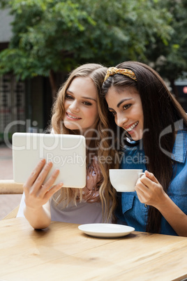 Smiling friends looking at tablet computer