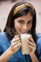 Smiling woman drinking cold coffee