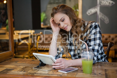 Woman using table computer while sitting at table