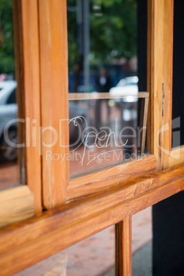 Open text on glass window of side walk cafe