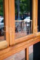 Open text on glass window of side walk cafe