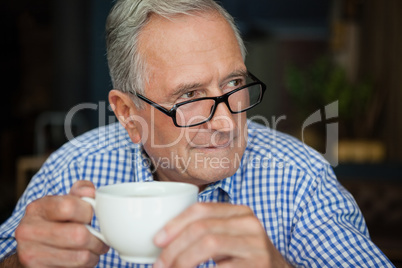 Thoughtful senior man sitting at cafe