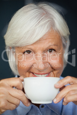Close up portrait of smiling senior woman with coffee cup