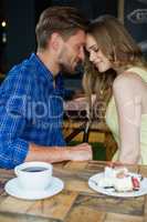 Close up of romantic couple with eyes closed sitting on chair