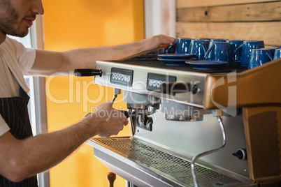 Waiter preparing coffee from coffee machine