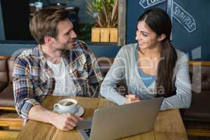 Young couple interacting while having coffee