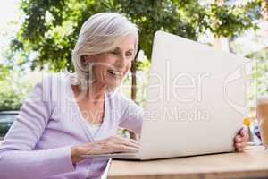 Senior woman using laptop in outdoor cafÃ?Â©