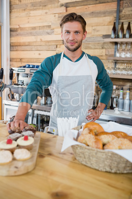 Smiling waiter standing at the counter in cafe