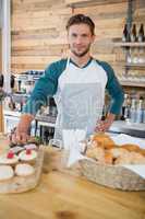 Smiling waiter standing at the counter in cafe