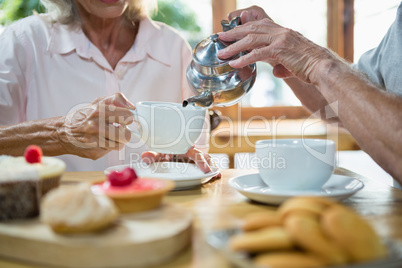 Senior man pouring tea into cup
