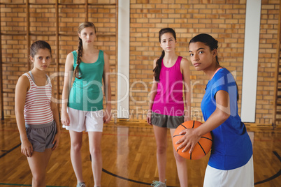 Portrait of high school kids standing with basketball