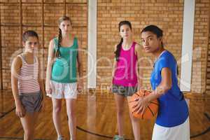 Portrait of high school kids standing with basketball