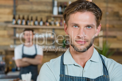 Portrait of waiter standing behind the counter