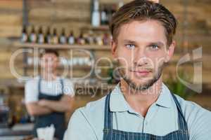 Portrait of waiter standing behind the counter