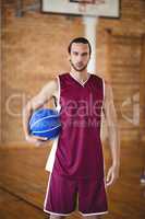 Confident basketball player holding a basketball