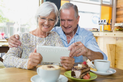 Happy senior couple using digital tablet